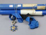 un rouleau de papier bleu sur lequel sont dessinés une étoile et une médaille