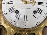 a gold clock with roman numerals on the face