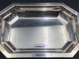 a silver plate with a black handle on a black table