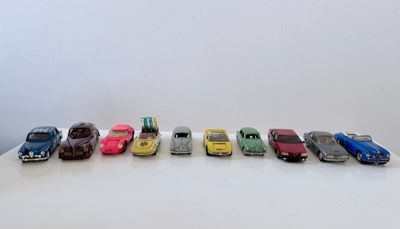 plusieurs petites voitures sont alignées sur une surface blanche