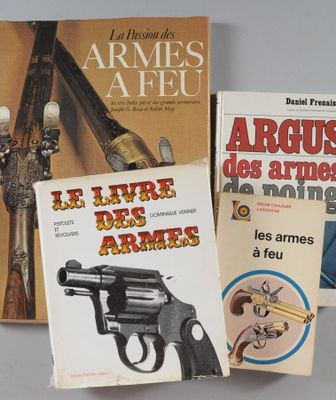 trois livres posés sur une table, avec un pistolet posé dessus