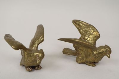 pair of brass figurines of a flying bird and a bird with a hat