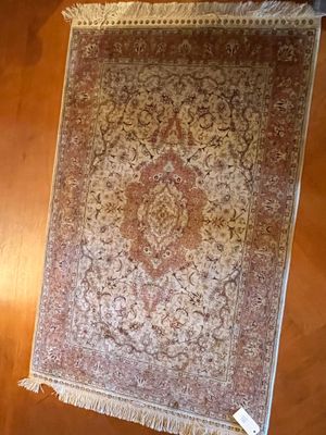 un tapis accroché au mur à côté d'une lampe