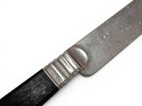 a close up of a knife on a white surface