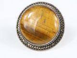 Bague en pierre « œil-de-tigre » rehaussée de touches d'argent sur fond blanc