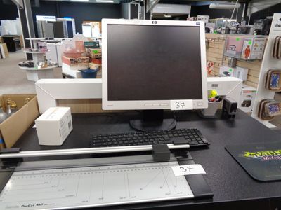 un écran d'ordinateur et un clavier posés sur un bureau dans un magasin