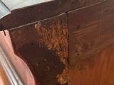 a close up of a wooden table with peeling paint on it
