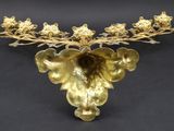 a gold vase with flowers on it on a black surface