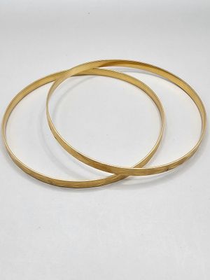two gold bang bracelets on a white background