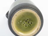 a close up of a vase on a white surface
