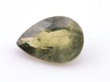 un gros plan d'un quartz vert posé sur une surface blanche