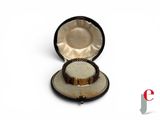 une petite boîte contenant une bague, posée sur une surface blanche