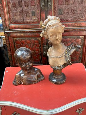 deux busturines posées sur une table rouge