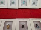 six boxes of different types of earphones on a red surface