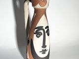 a vase with a face painted on it on a white surface