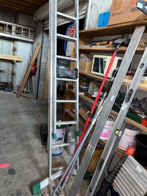 une photo d'un garage avec des échelles et des outils