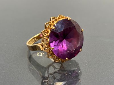 an image of a purple stone ring on a black surface