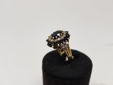 a close up of a gold ring with black stones on a black ring holder
