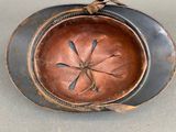 a metal bowl with a flower on it on a table