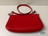 the red purse is sitting on a white surface