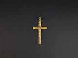une croix dorée sur une surface noire, avec un fond noir