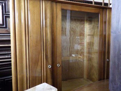 a wooden cabinet with a glass door in a room