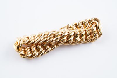 a close up of a gold chain bracelet on a white background