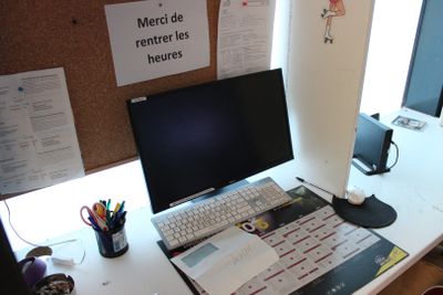 un bureau sur lequel se trouvent un ordinateur, un clavier, une souris et des papiers