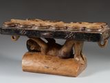 an image of a wooden sculpture of a man holding a large piece of wood