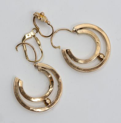 une paire de boucles d'oreilles en or sur fond blanc