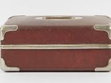 a small brown suitcase sitting on a white surface