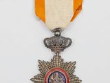 un gros plan d'une médaille posée sur une surface blanche, accompagnée d'un ruban