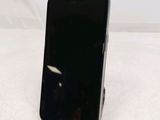 a black cell phone sitting on a stand on a table