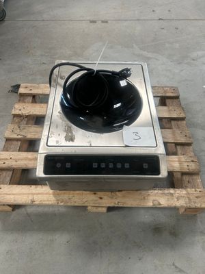un bol noir posé sur une cuisinière, elle-même posée sur une palette