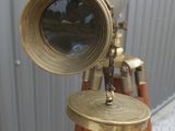 an antique brass telescope on a wooden tripod with a metal stand