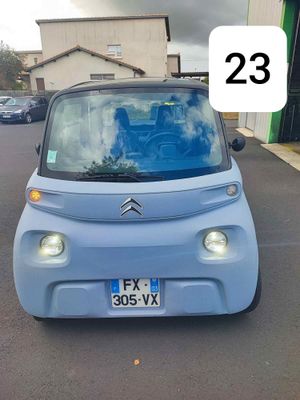 une petite voiture bleue garée sur le bord de la route