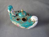 a small teapot with a bird on it on a table
