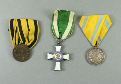 three medals and a medal on a gray surface