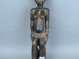 un gros plan sur une statue en bois représentant une personne torse nu