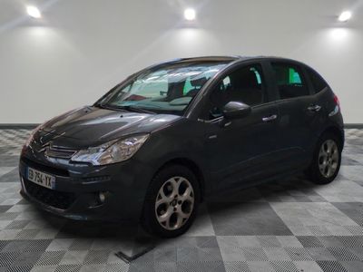 la voiture noire est garée sur un sol en damier dans le garage
