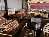 de nombreuses pièces de bois empilées dans un entrepôt