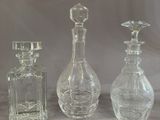 three glass bottles sitting next to each other on a table