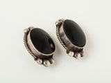 a pair of silver and black onyx earrings on a white surface