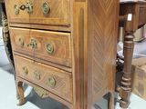 a wooden chest of drawers with a marble top