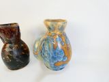two vases sitting next to each other on a white surface