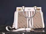 a white and brown handbag sitting on top of a table