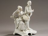 une figurine représentant un homme et une femme assis sur un banc