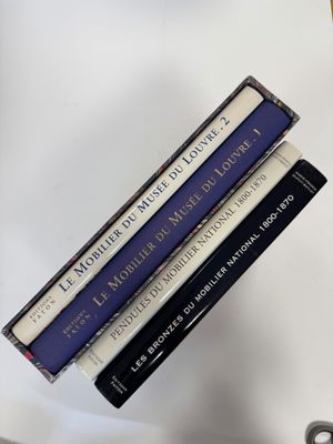 trois livres sont empilés sur une table