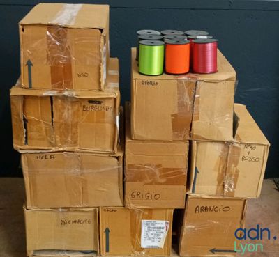 several boxes stacked on top of each other with different colored spools on them