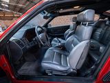 the interior of a red car with leather seats and a steering wheel